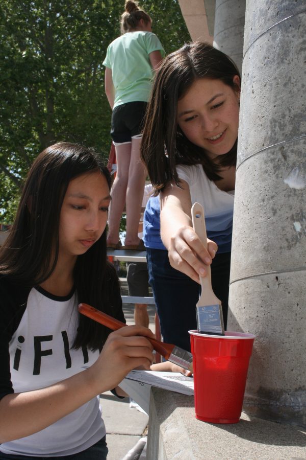 Sharing the same paint bucket, sophomores Kiana Abrigana and Marisa Wong paints a pillar after school at 2:45 on April 9. Along with the rest of the National Honors Society (NHS) club, they were priming two of the school pillars. “The project is called ‘Paint a Pillar’ and we will be painting everyday except Saturday and we should be done on Monday” said Sophomore Marisa Wong. Photo by Nishita Fernandes