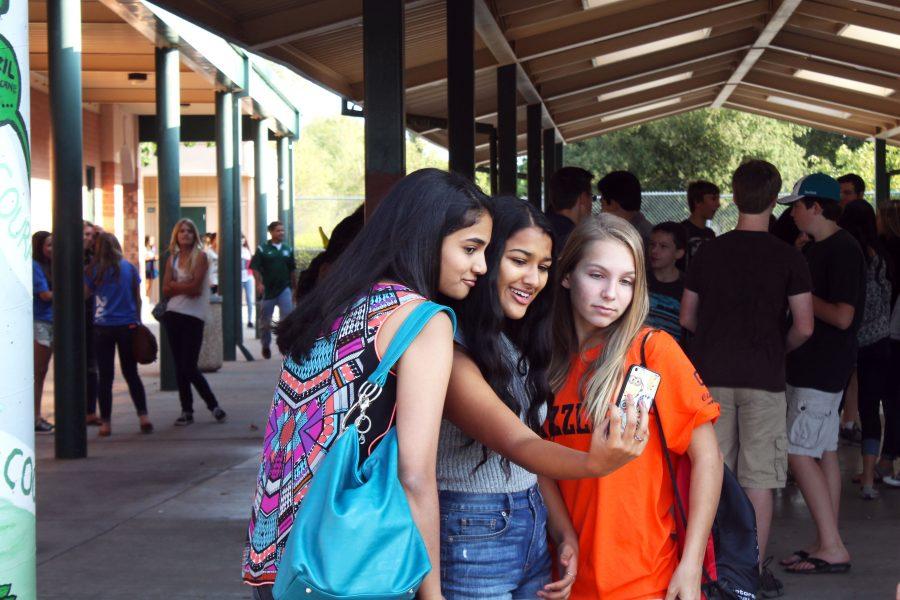 #SELFIE Stopping to snap a quick selfie, freshmen Tanvi Yadlapalli, Anvita 
Gattani, and Sienna Unter are all smiles as they enjoy a backpack-free first day of school. This year, school started with a special 20th anniversary celebration that included rallies, meetings, and best of all, no backpacks! “I liked it because you didn’t have to stress that much on the first day of school”, Yadlapalli said. “But I still brought a handbag to put my lunch and phone in.” Photo by Frances Strnad 