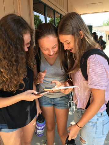 Left to Right: Brenna Halloran, Emily Bradley and Jaclyn Ohlsen gasp while looking at a review on the Rate My Teacher app