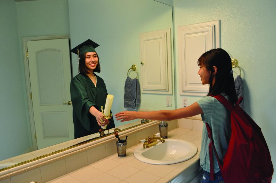 Incoming freshman Olivia Matthews stares at her reflection, seeing a graduating senior (senior Isabella Matthews) smiling back at her. Isabella Matthews passes the baton to her younger sister, representing whats to come after four years of hard work.