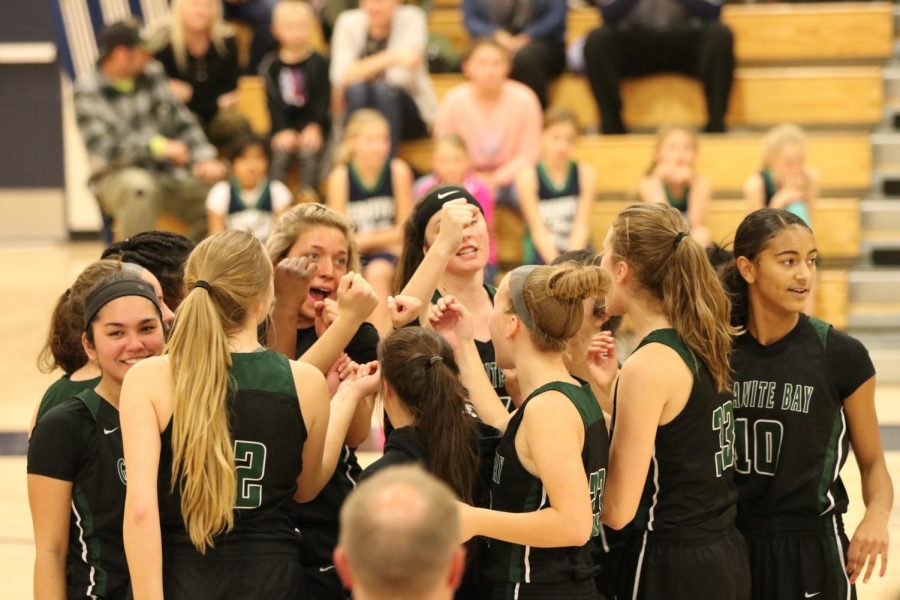 The girls’ varsity  basketball team huddles before their league match-up against Oak Ridge High School.
