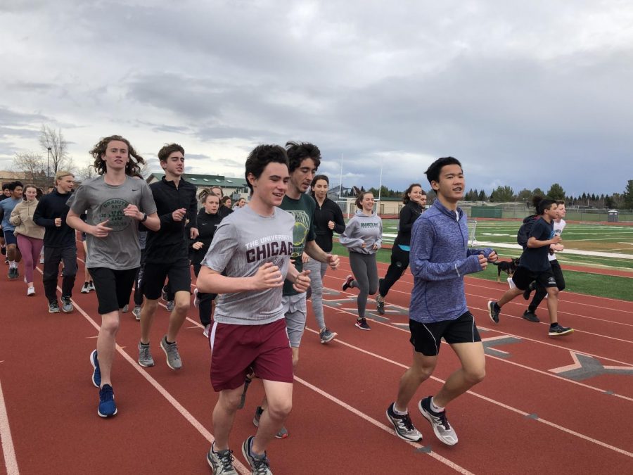The track and field team runs warm-up laps for an after-school practice session.