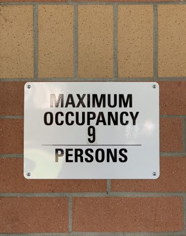 Maximum occupancy signs are affixed next to every bathroom on campus with multiple stalls.