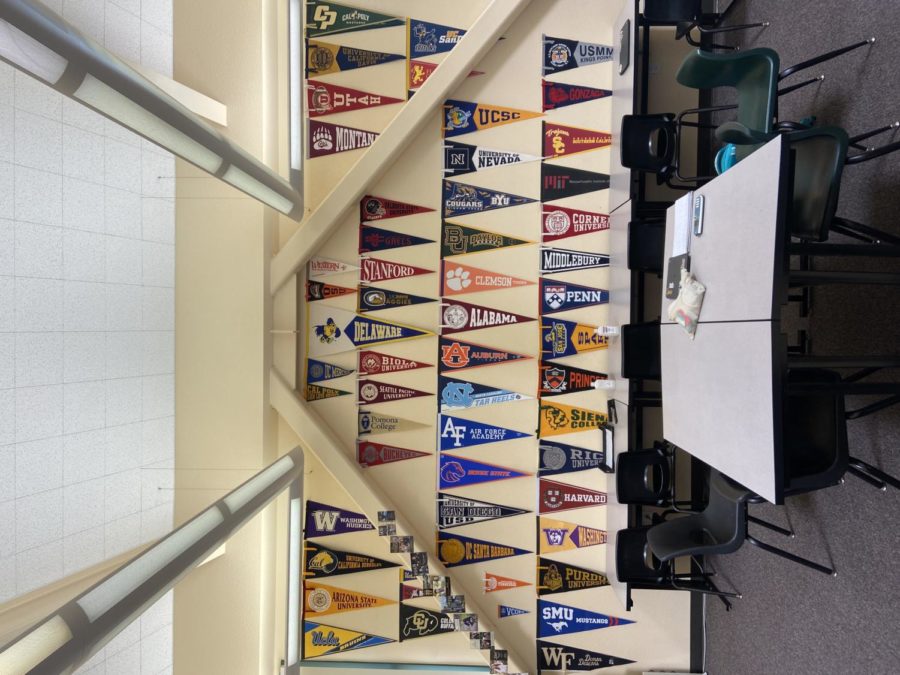 Mr. Moore dedicates his back wall full to his former students.
“When they go off to [college] they get one of those [pennants] for the school they go to, Moore said. 
Along with the pennants, some students will send in holiday cards or postcards, which he places frames on the left diagonal beam.