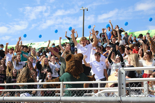 The crowd goes wild when the school mascot, Big G, makes his way through the bleachers to greet students during the homecoming spirit rally.