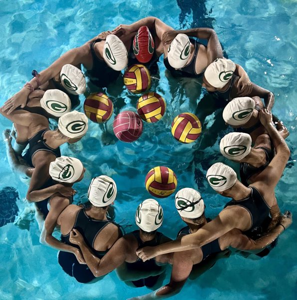 The JV girls water polo team gather for a group huddle as the time until their game runs out. Captains, Sarah Baxter and Ava Preininger lead the chant.“GB on me GB on three! One, two, three. GB!” shouts the whole team
