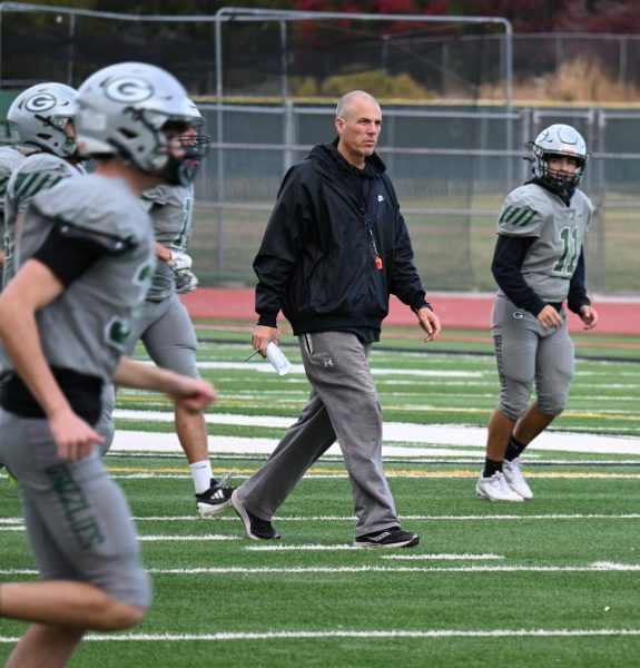 Coach Catillico leads the players down the field as they begin running, throwing, and kicking drills.