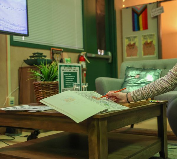 In this photo illustration, a student is coloring in a coloring book provided by the Wellness Center.