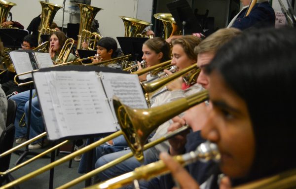 One of the band's biggest and most important instruments is the Trombone. This section consists mostly of new member Freshmen including Reva Vallurupi, Kyle Vadnais, Lily Brooks, Caleb Adriano and William Xiong. They also have a few returning members helping these new musicians such as Nolan Meier, Lilli Collamer and Concert band members Keith Vance and Niko Kartvelli. These hardworking musicians have been working extremely hard since July in their Band Camp and performing their best. In this photo, these musicians are all practicing their important parts and are preparing for their teacher Lewis to call the band and rehearse together as a whole. "It's fun, because we are all good friends...and we all like to help and support each other," Lily Brooks said, "I usually distance myself so I don't get stressed out, I'll warm up and breathe so I'm chill."