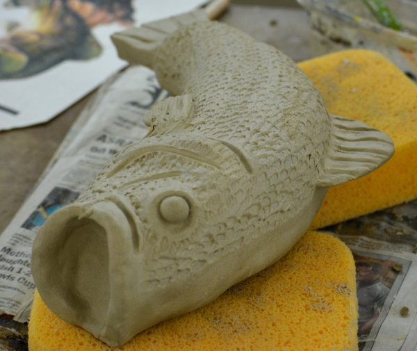 Ceramics students don't always do sculptures on people, they also make a lot of sculptures on many animals as well. This student carefully makes the scales of the fish by creating small dents into the clay to make their sculpture more abstract.