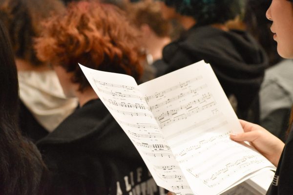 In the auditorium, everyone sits together, studying the new music.