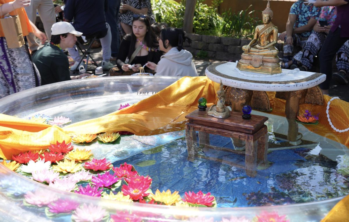 The Buddha statue immersed in water symbolizes respect and new beginnings during Songkran.
