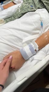 Isabella Ferrante holding Puccinelli's hand in the hospital.
